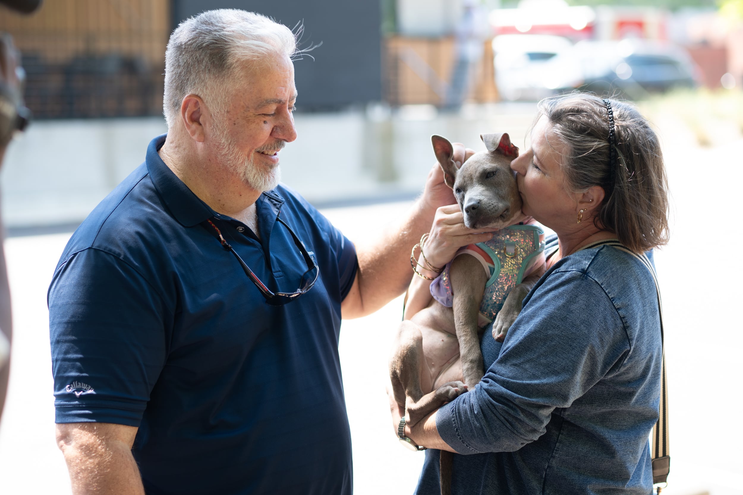 Couple kissing newly adopted puppy at Adopt and Shop community event in Atlanta