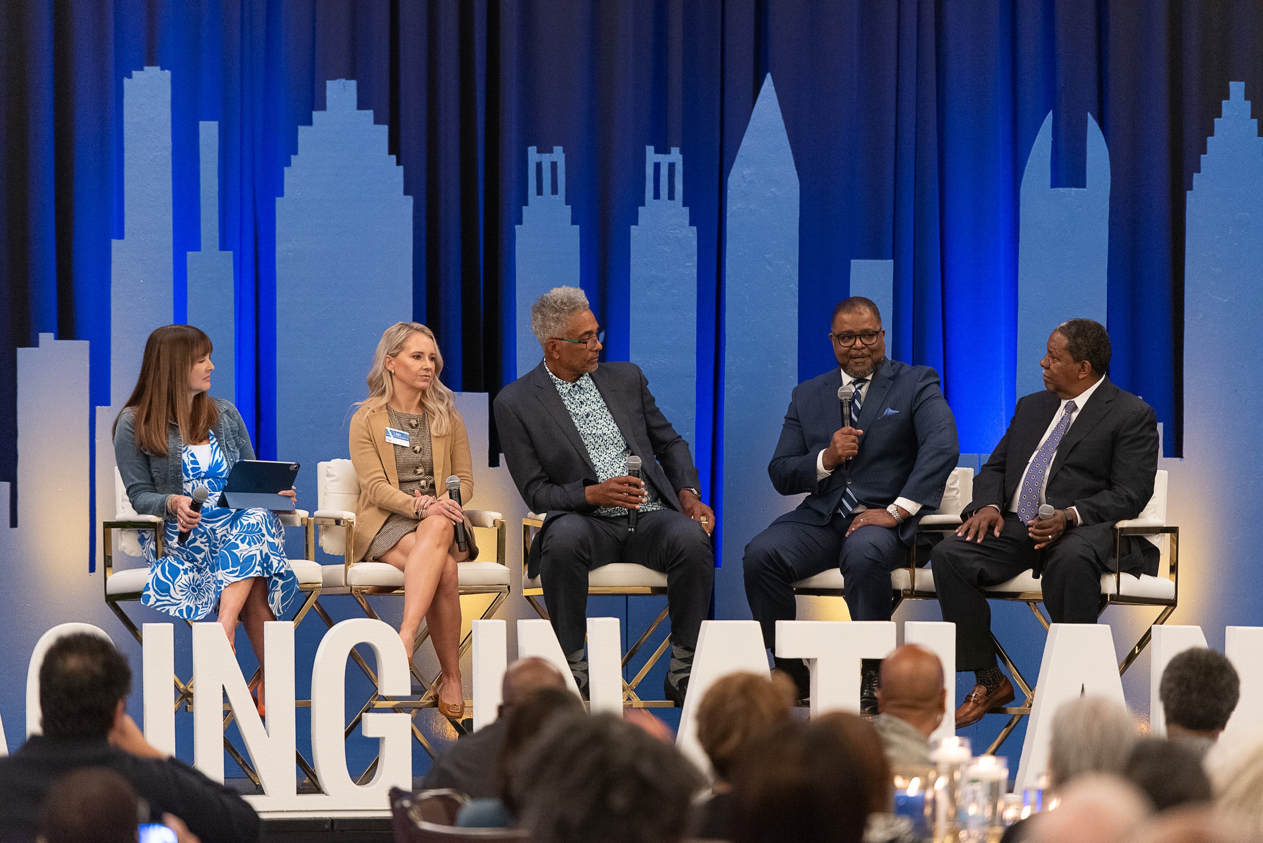 Panel discussion at AJC Live Aging in Atlanta conference with Atlanta skyline stage design