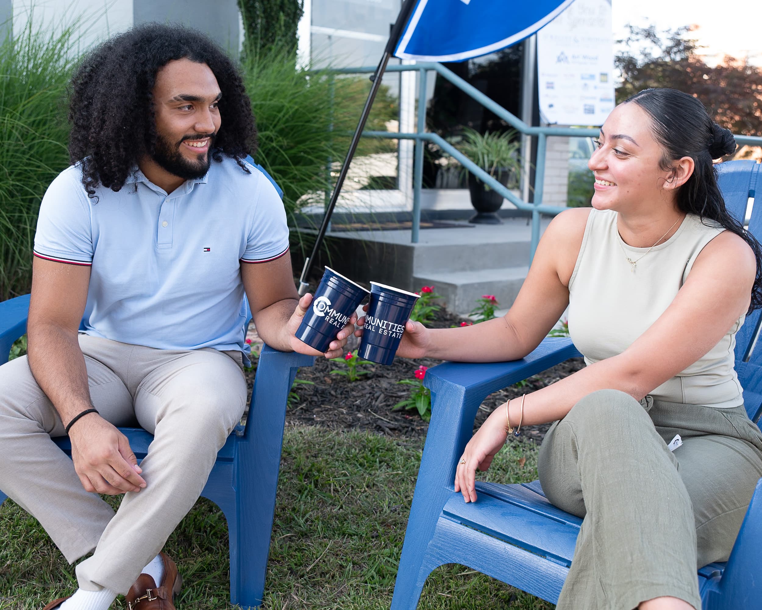 Candid moment of two young professionals laughing at Communities Real Estate outdoor event