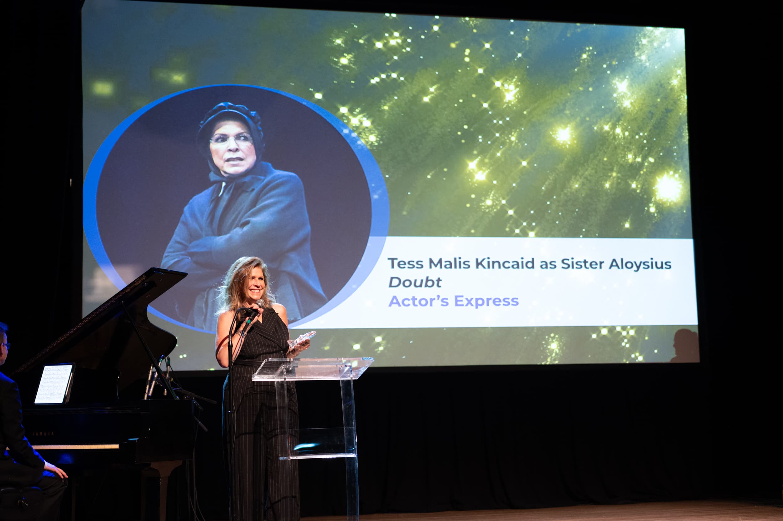 Actress accepting award at podium during the Suzi Bass Awards ceremony in Atlanta