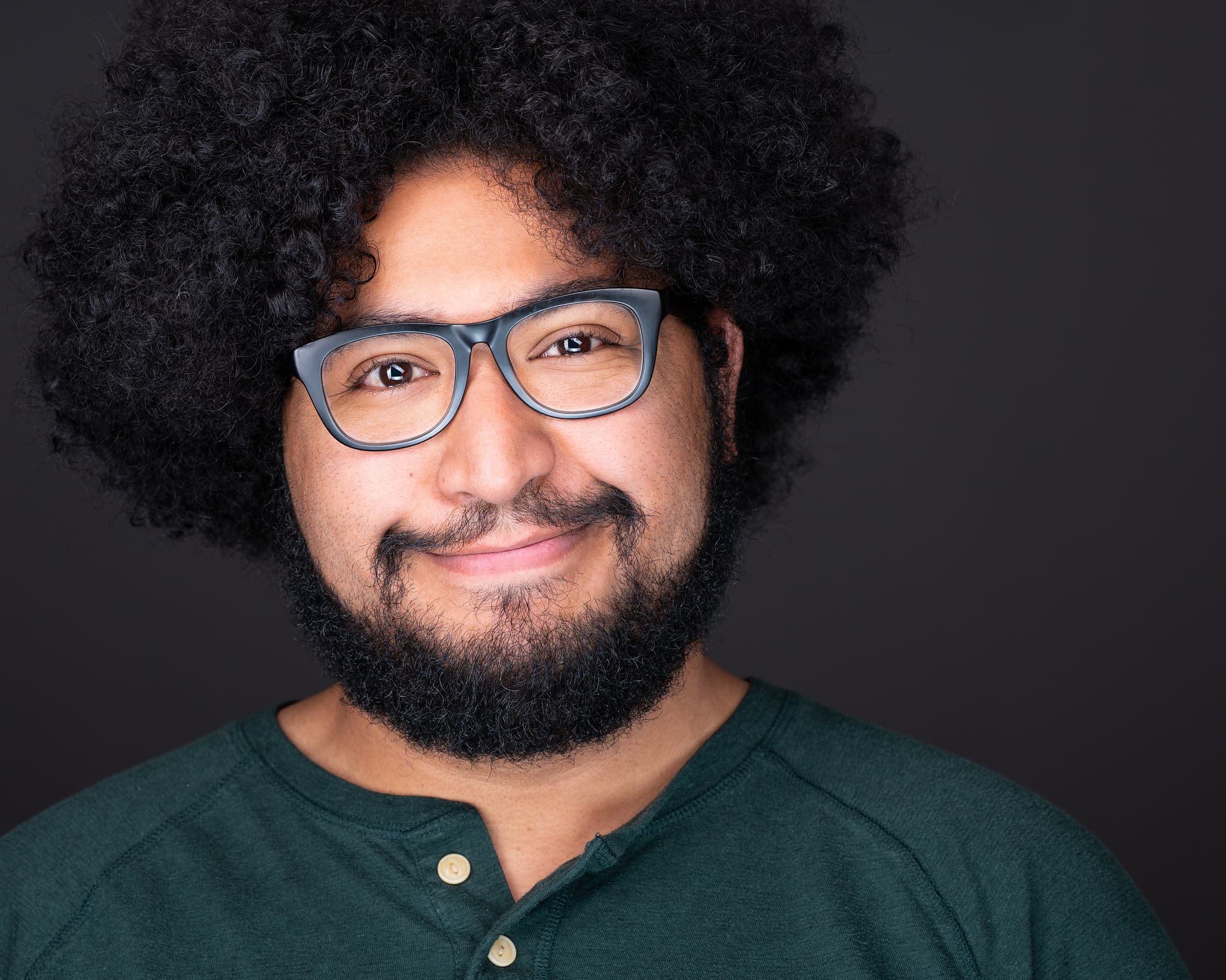 Creative professional headshot of man with glasses in casual green henley