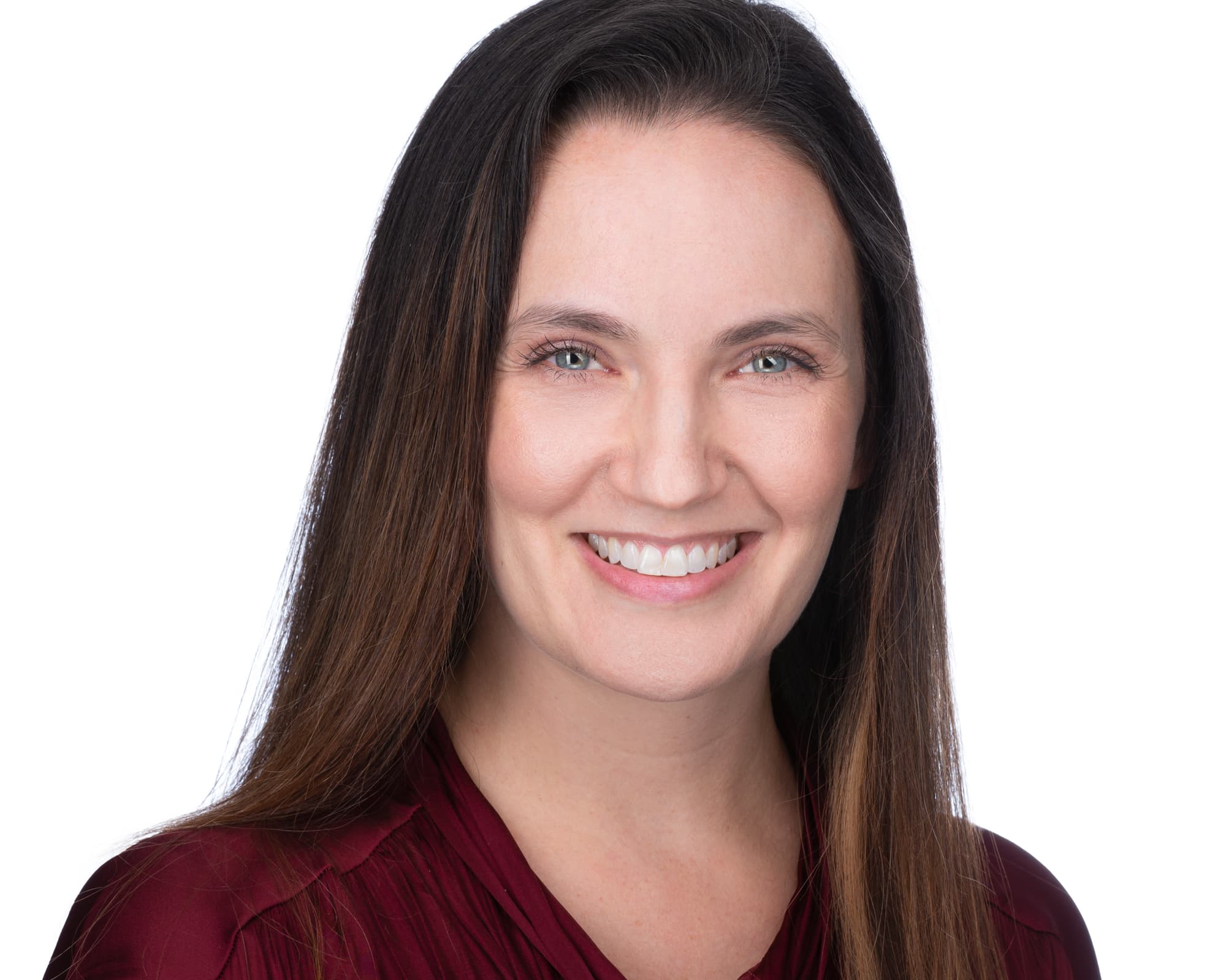 Professional headshot of woman in burgundy blouse on white background by RMO Photography
